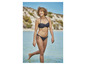 Vrouw in een zwarte bikini met witte stippen op een strand.
