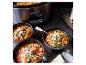 Een Crock-Pot slowcooker met drie kommen tomatensoep.