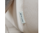 Close-up van een lichte textiel met een label met een logo en tekst.