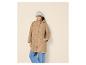 Vrouw in beige jas, jeans en grijze muts.