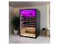 Moderne infraroodsauna met paarse verlichting en houten interieur in een badkamer.