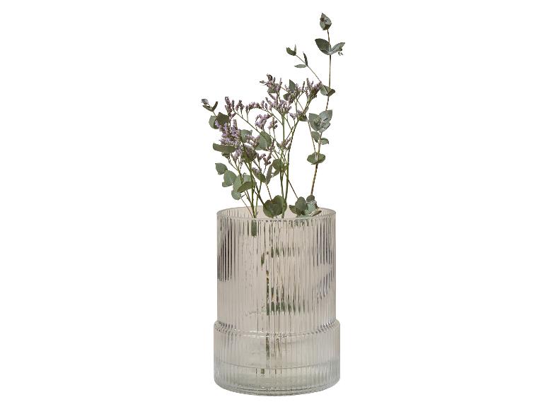 Geribbelde glazen vaas met paarse bloemen en eucalyptus takken