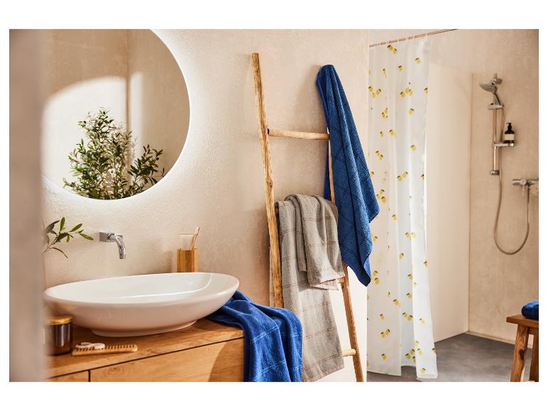 Handdoeken, douche en houten ladder in een badkamer met mediterrane stijl.