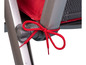 Detail van een vouwstoel met een rode koord om de rugleuning te bevestigen.