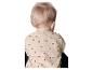 Achterkant van een baby in een beige shirt met zwarte stippen, met knoopjes in de nek.