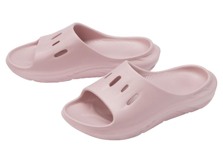 Een paar roze schuimrubberen slippers met uitsparingen aan de bovenkant