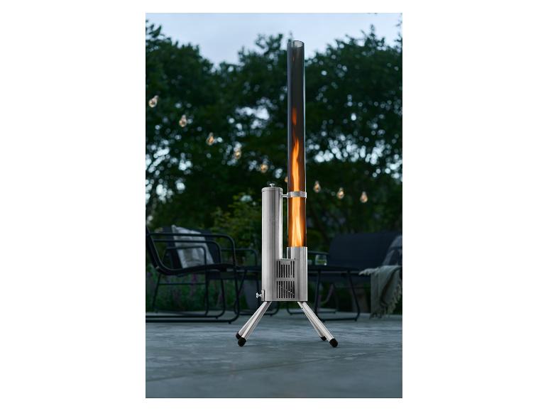 Terrasverwarmer met vlam in een glazen buis, in een tuin met lichtslingers.