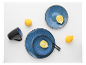 Blauw servies, zwarte mok en citroenen.