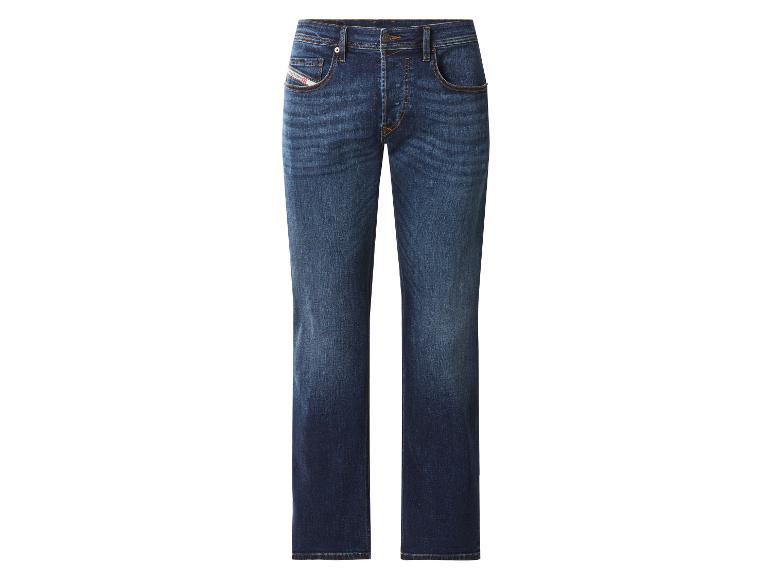 Donkerblauwe jeans met lichtere plekken en oranje stiksels.