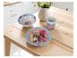 Barbie servies set met bord, kom en mok op een houten tafel.
