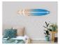 Houten surfplank aan de muur boven een bed met kussens en planten.