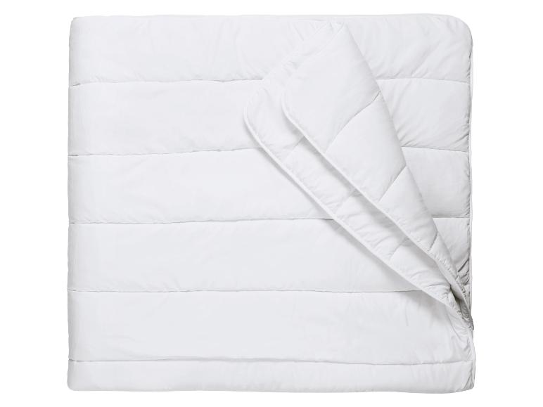 Wit dekbed met horizontale stiksels, gedeeltelijk gevouwen