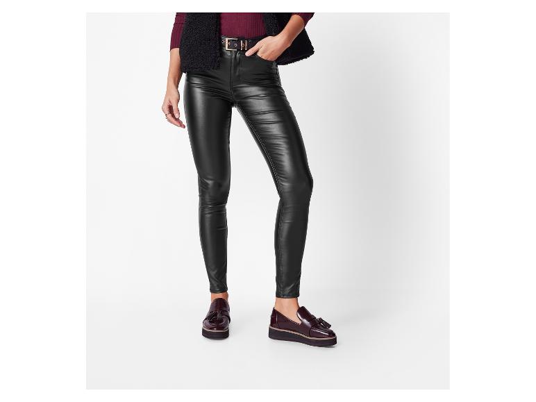 Vrouw draagt zwarte skinny jeans van imitatieleer en bordeauxrode plateau loafers.