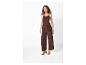 Vrouw in een bruine jumpsuit met ceintuur, draagt bruine sandalen met hak.