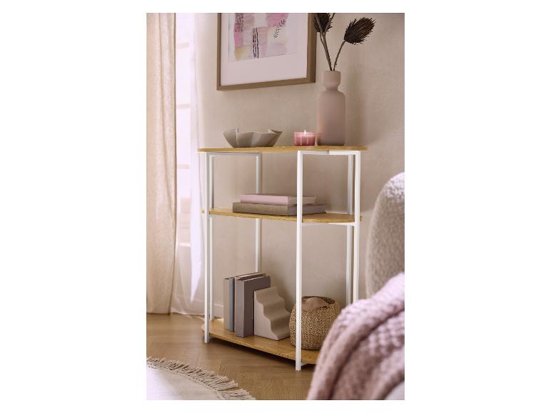 Houten rek met witte metalen poten, boeken, een vaas en een kaars in een gezellige kamer.