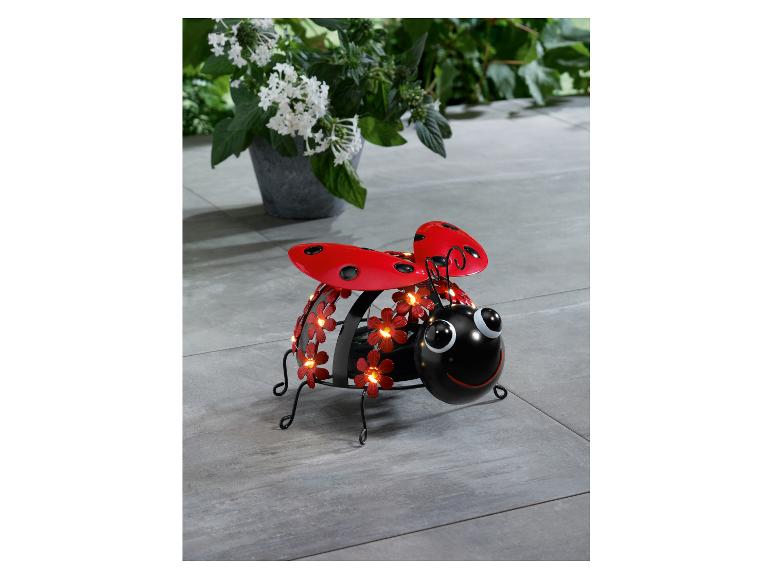 Een metalen lichtsnoer in de vorm van een lieveheersbeestje met rode bloemen.