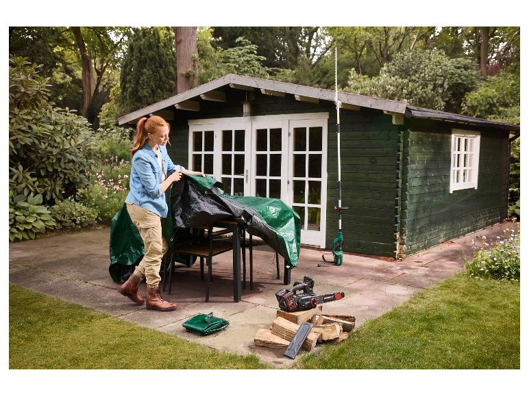 Een vrouw dekt tuinmeubelen af met een universeel PARKSIDE afdekzeil.