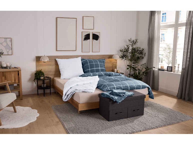 Gezellige slaapkamer met houten bed, blauw geruit beddengoed en grijs vloerkleed.