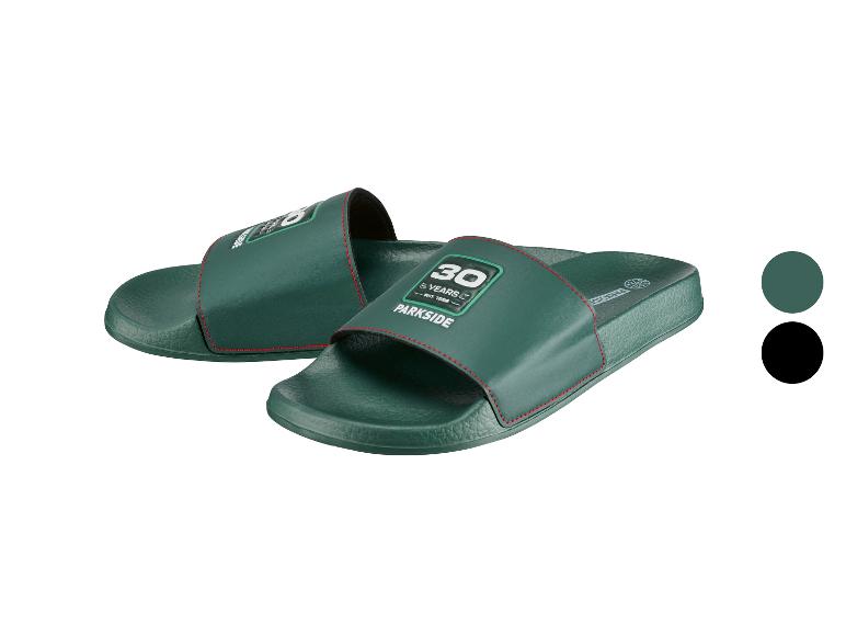 Groene slippers met de tekst '30 YEARS EST. 1996' en rode stiksels.