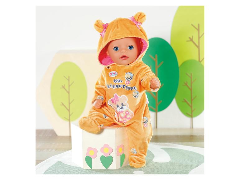 BABY born pop in oranje bijenkostuum met tekst 'OH, BEEAUTIFUL', zittend op een doos.