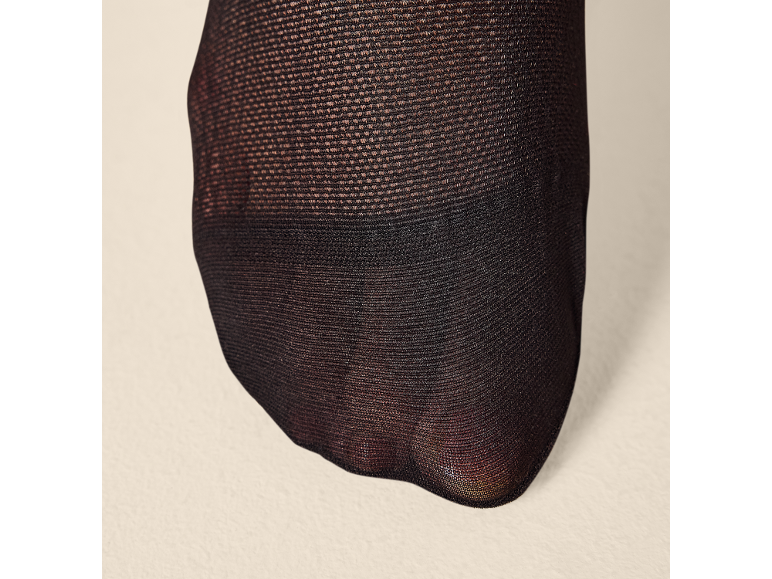 Zwarte panty met transparant weefsel dat een voet bedekt.