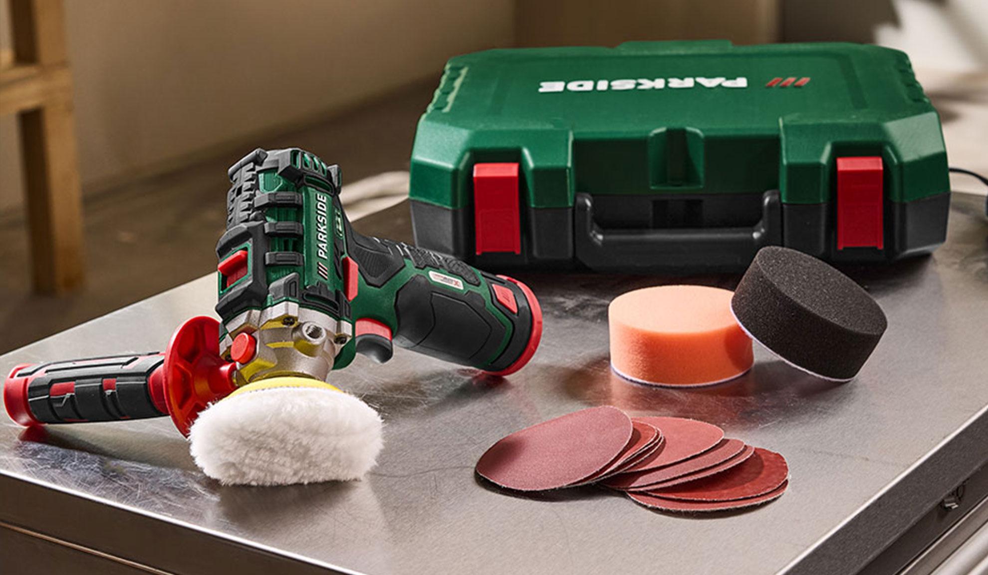 Accupolijstmachine met accessoires, inclusief polijstpads en schuurpapier.