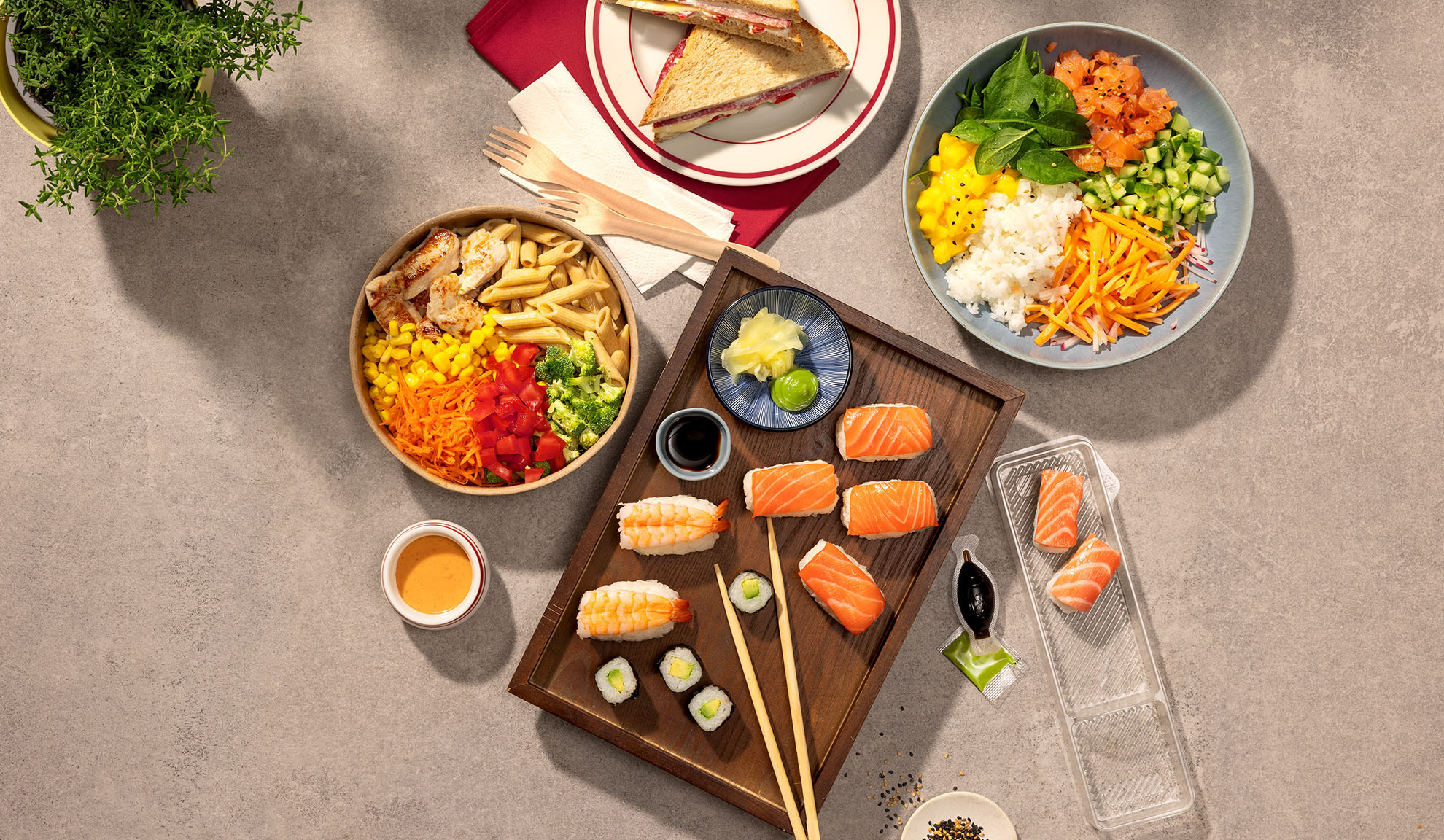Overzichtsfoto van diverse afhaalmaaltijden: sushi, poké bowl, pastasalade en sandwiches.