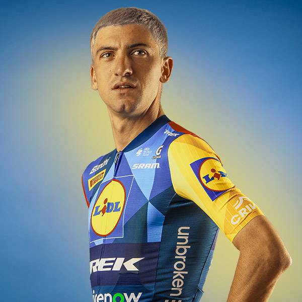 Wielrenner in blauw en geel shirt met geometrische patronen en tekst 'unbroken'.