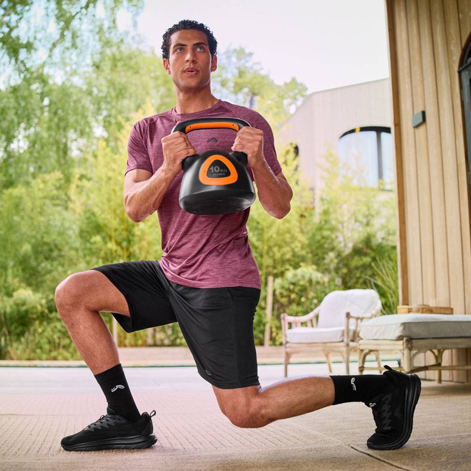 Man doet lunges met een 10 kg kettlebell buiten.