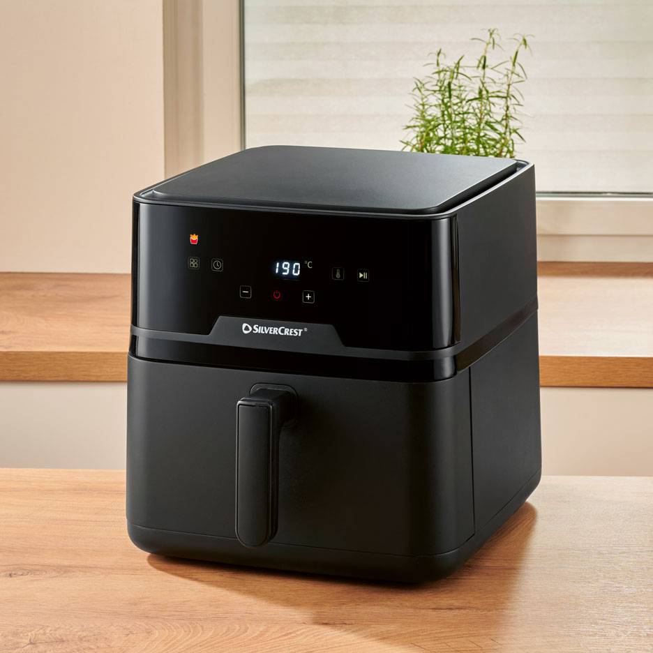 Zwarte digitale heteluchtfriteuse op een houten tafel, met 190 °C op het display.
