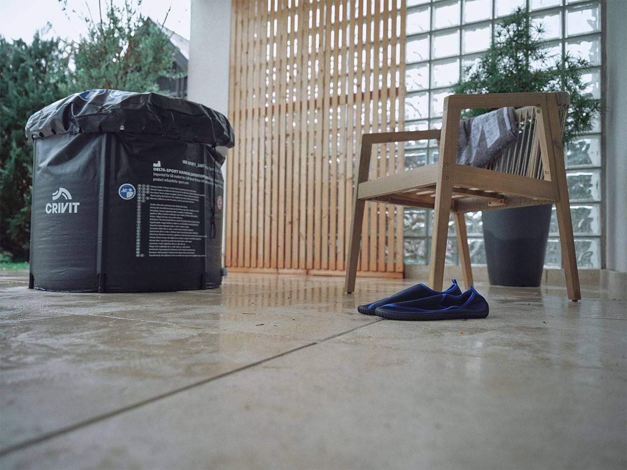 Crivit opblaasbaar zwembad en waterschoenen op een terras.