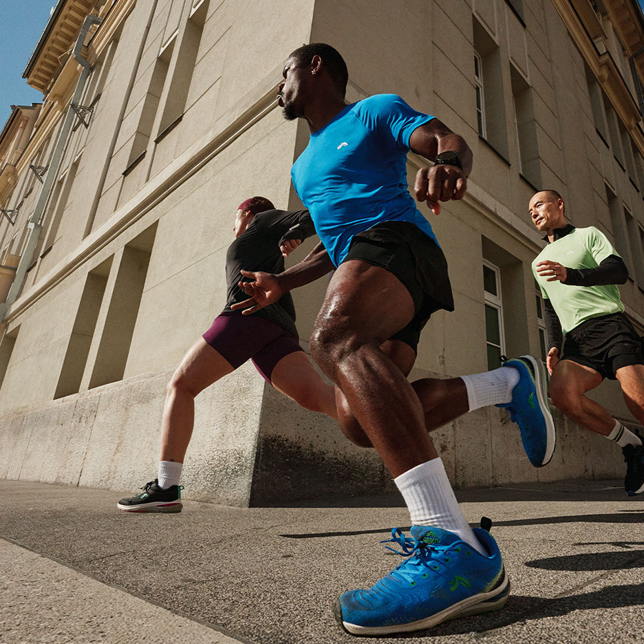 Drie mensen rennen op straat in sportkleding en hardloopschoenen.