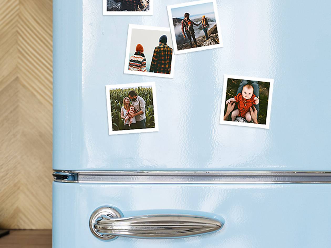 Blauwe koelkast met familiefoto's en babyfoto's.