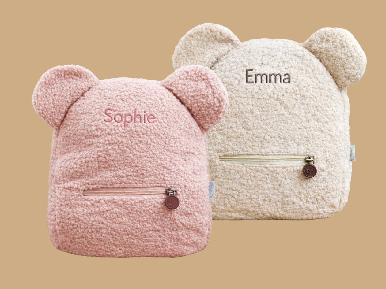 Roze en beige teddy rugzakken met oren, gepersonaliseerd met de namen 'Sophie' en 'Emma'.