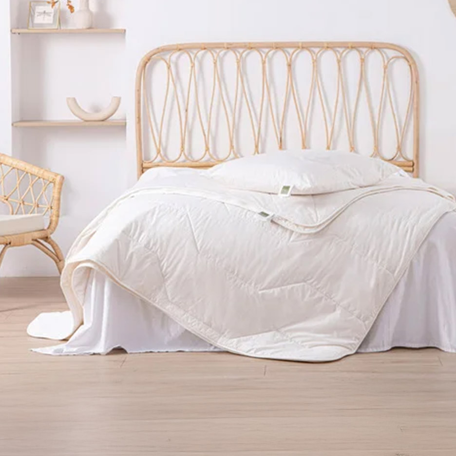 Bed met rotan hoofdeinde, wit dekbed en kussen