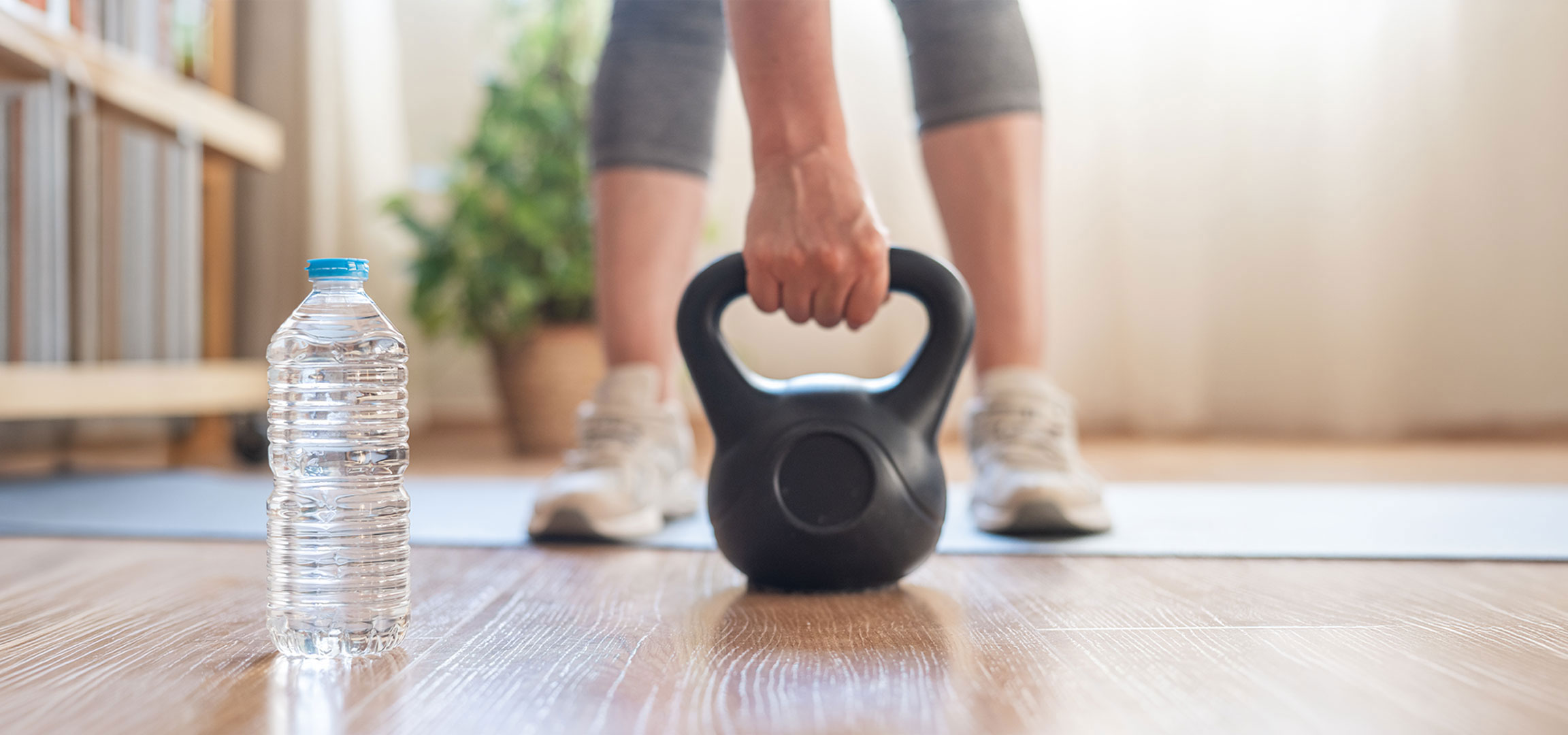 Gegenereerd door AI: Vrouw bereidt zich voor op training met een kettlebell en waterfles op een yogamat.