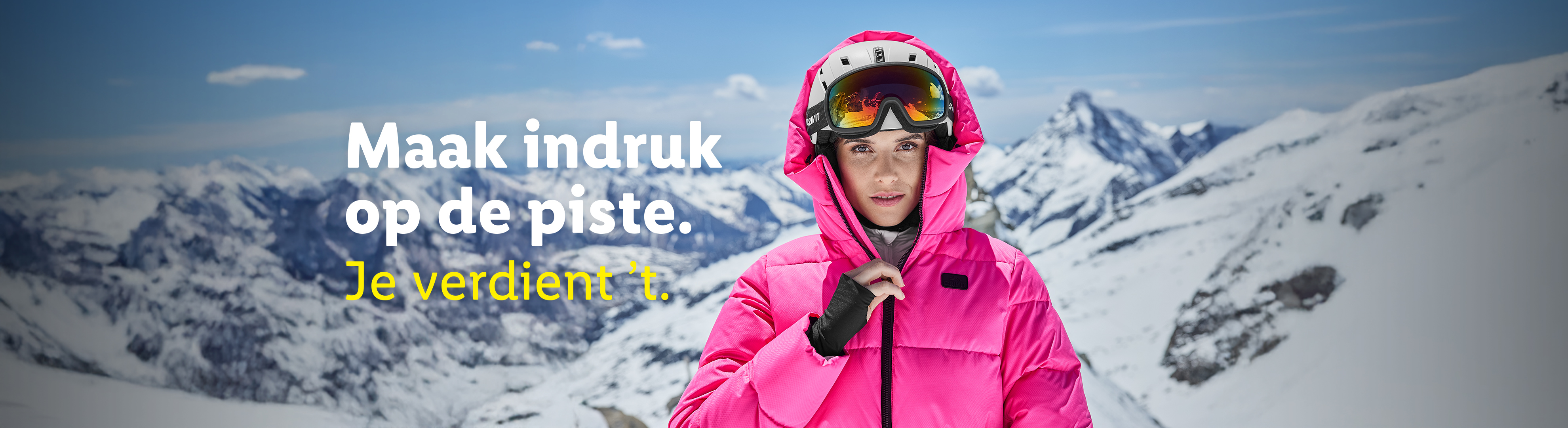 Vrouw in roze ski-jas en skihelm met skibril, met besneeuwde bergen op de achtergrond. Tekst: 'Maak indruk op de piste. Je verdient 't.'