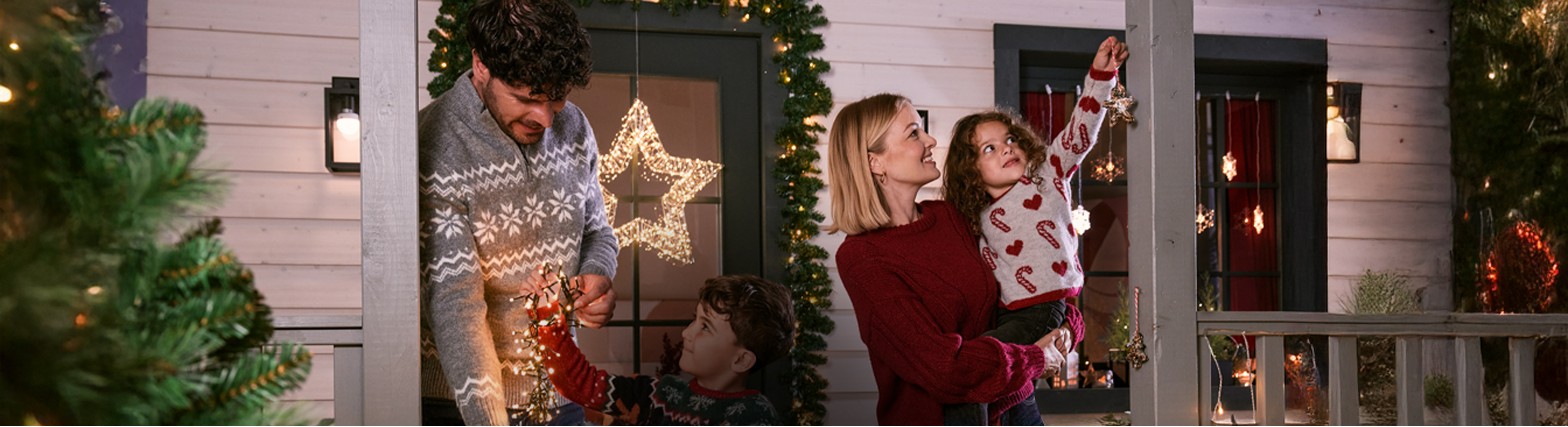 Een gezin versiert hun huis met kerstverlichting en kerstdecoratie.