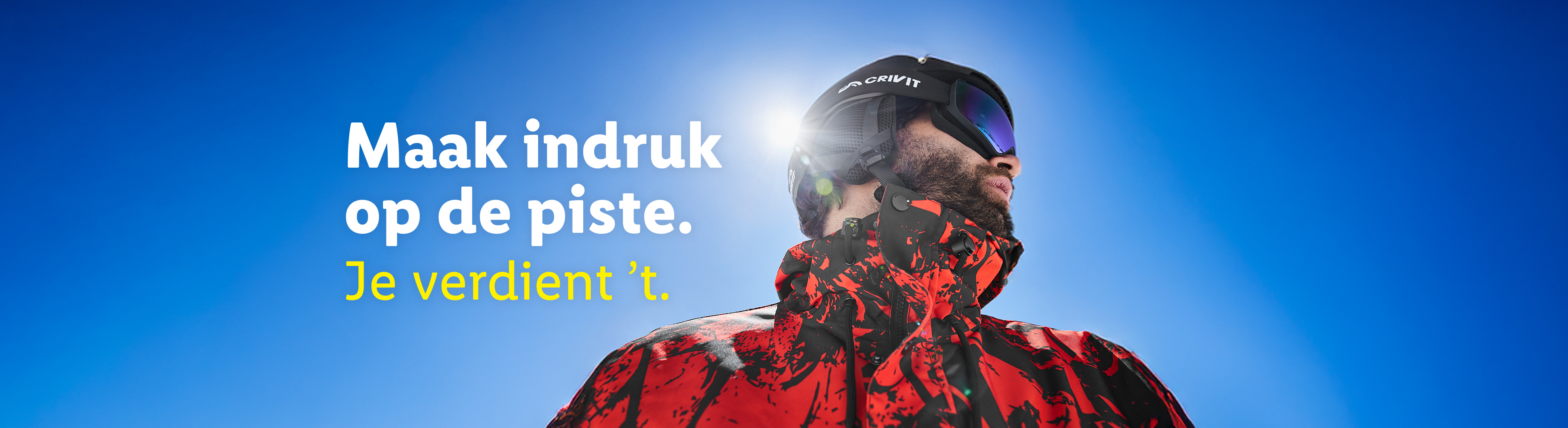 Man in Crivit skihelm en skibril met rode jas, tekst: Maak indruk op de piste. Je verdient 't.