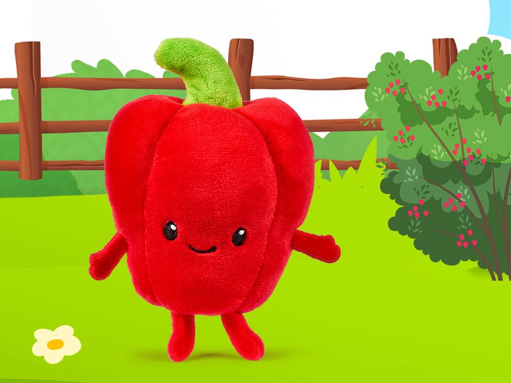 Een rode paprika knuffel met een groen steeltje, lachend in een groene tuin met een hek en struiken.