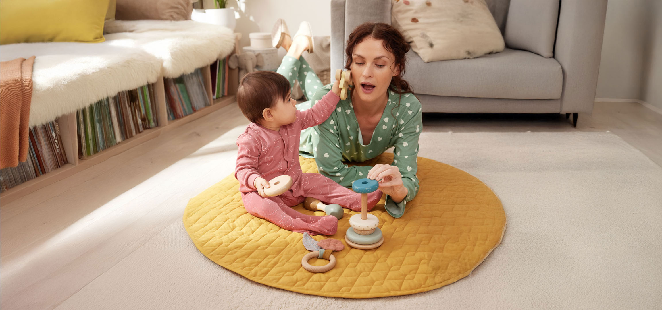 Moeder en baby spelen met speelgoed op de vloer.