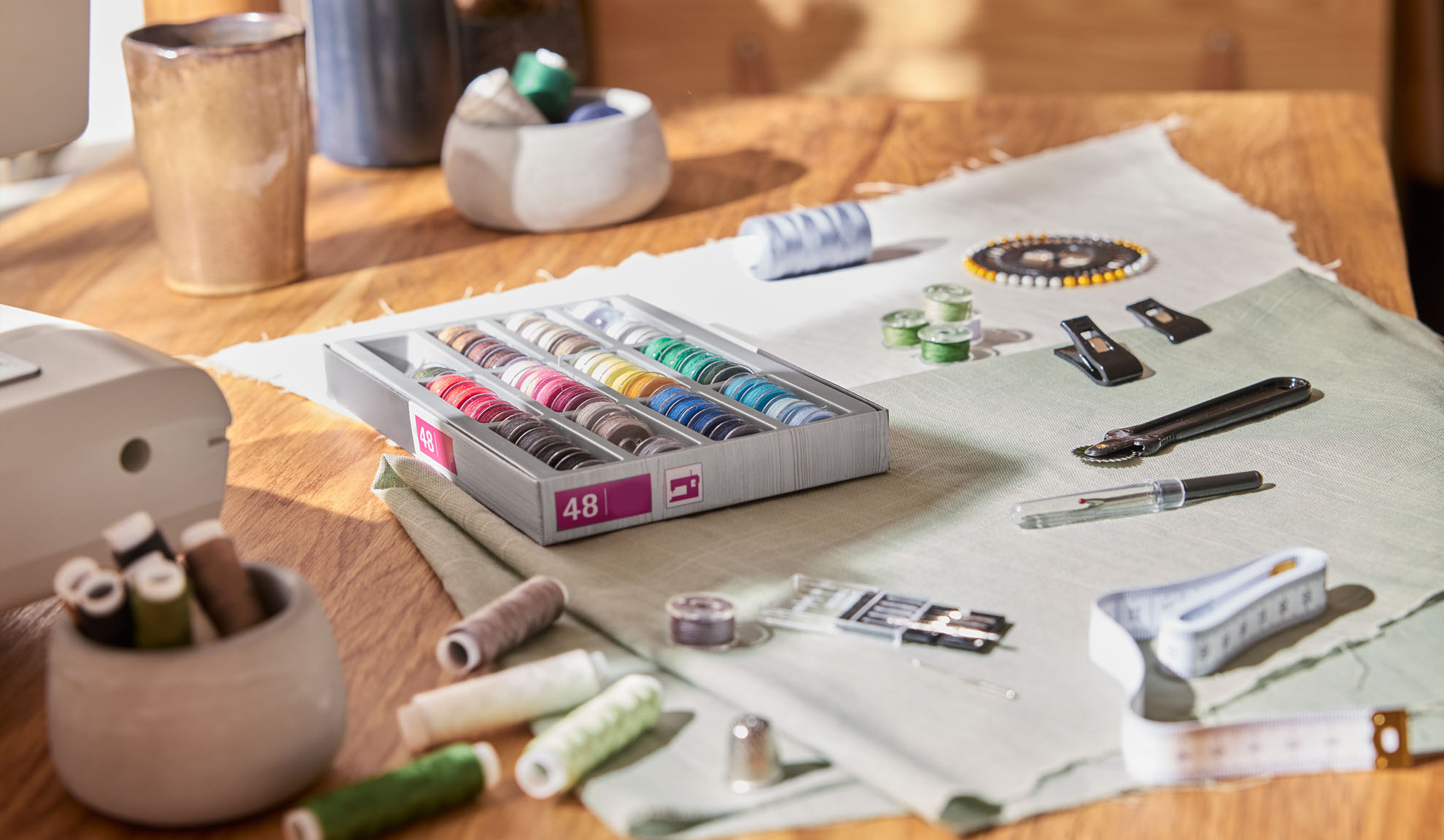 Naaiset met een doos kleurrijke draden, naaimachine en diverse gereedschappen op een houten tafel.