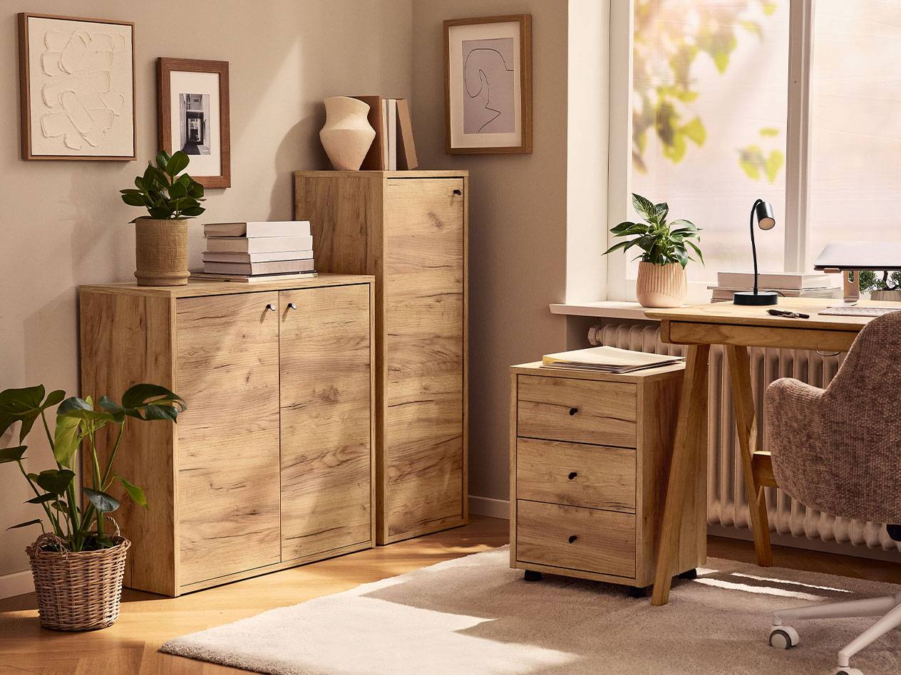 Een thuiskantoor met lichte houten kasten, een bureaustoel en een bureaulamp.