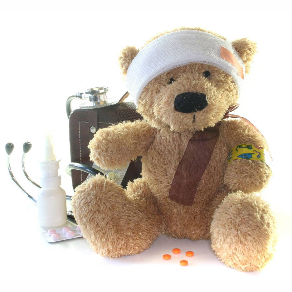 Gewonde teddybeer met verband, EHBO-koffer, stethoscoop en medicijnen.