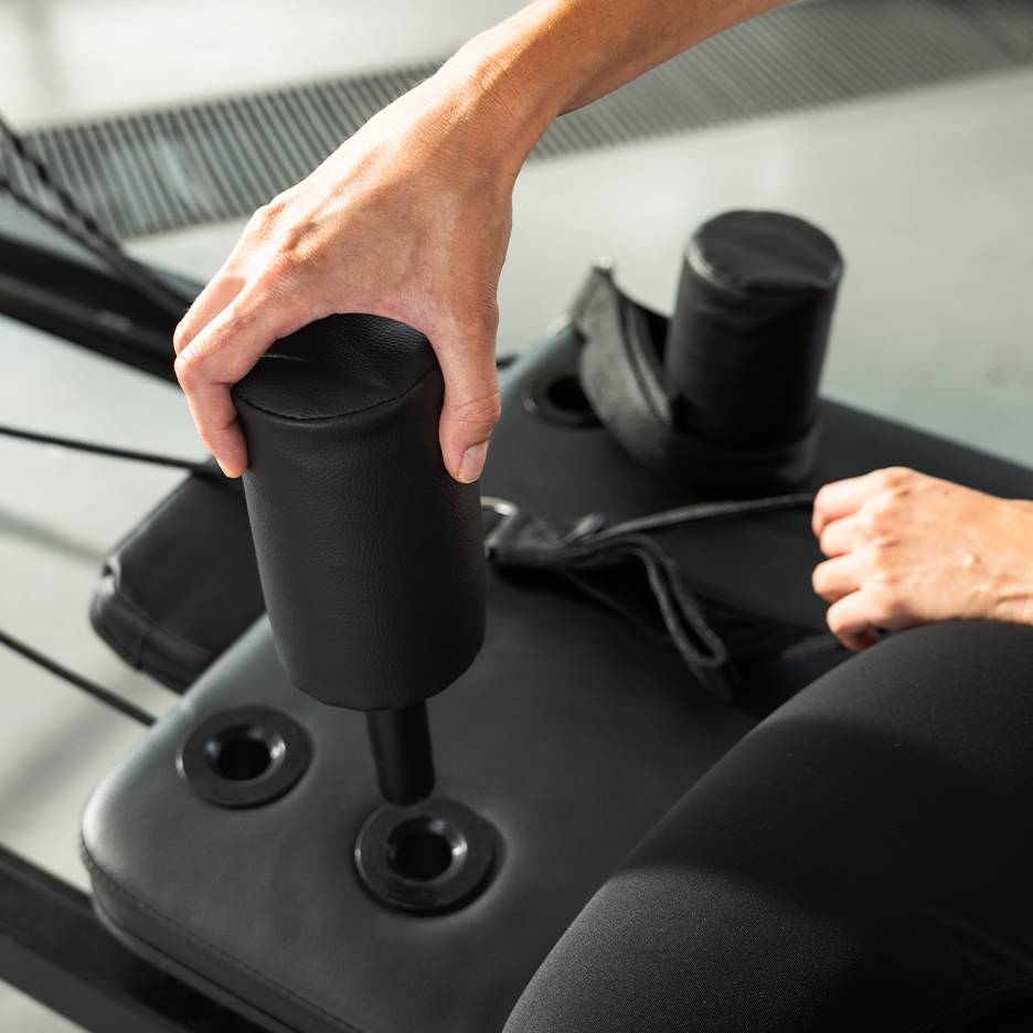 Persoon stelt een zwart gevoerd fitnessapparaat af.