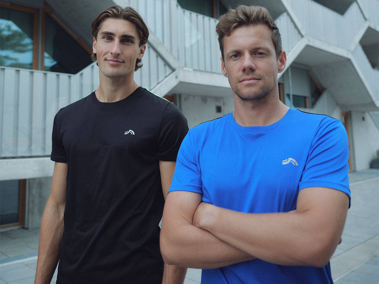 Twee mannen in zwarte en blauwe sport T-shirts met logo.