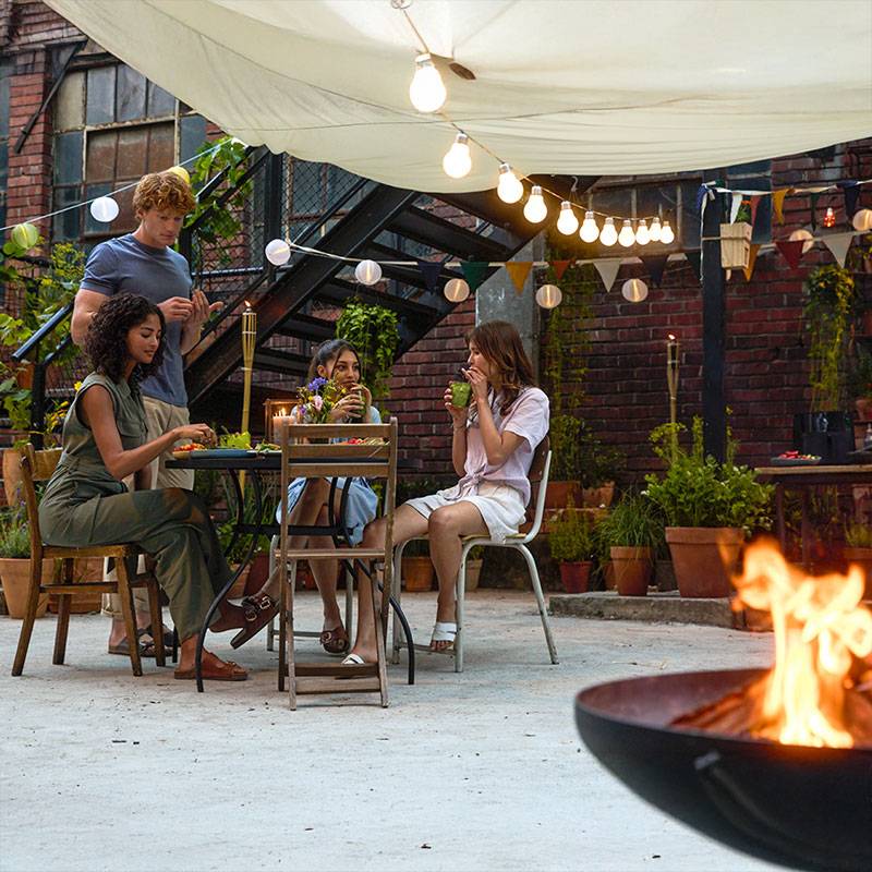 Vrienden genieten van een diner buiten onder de lichten.