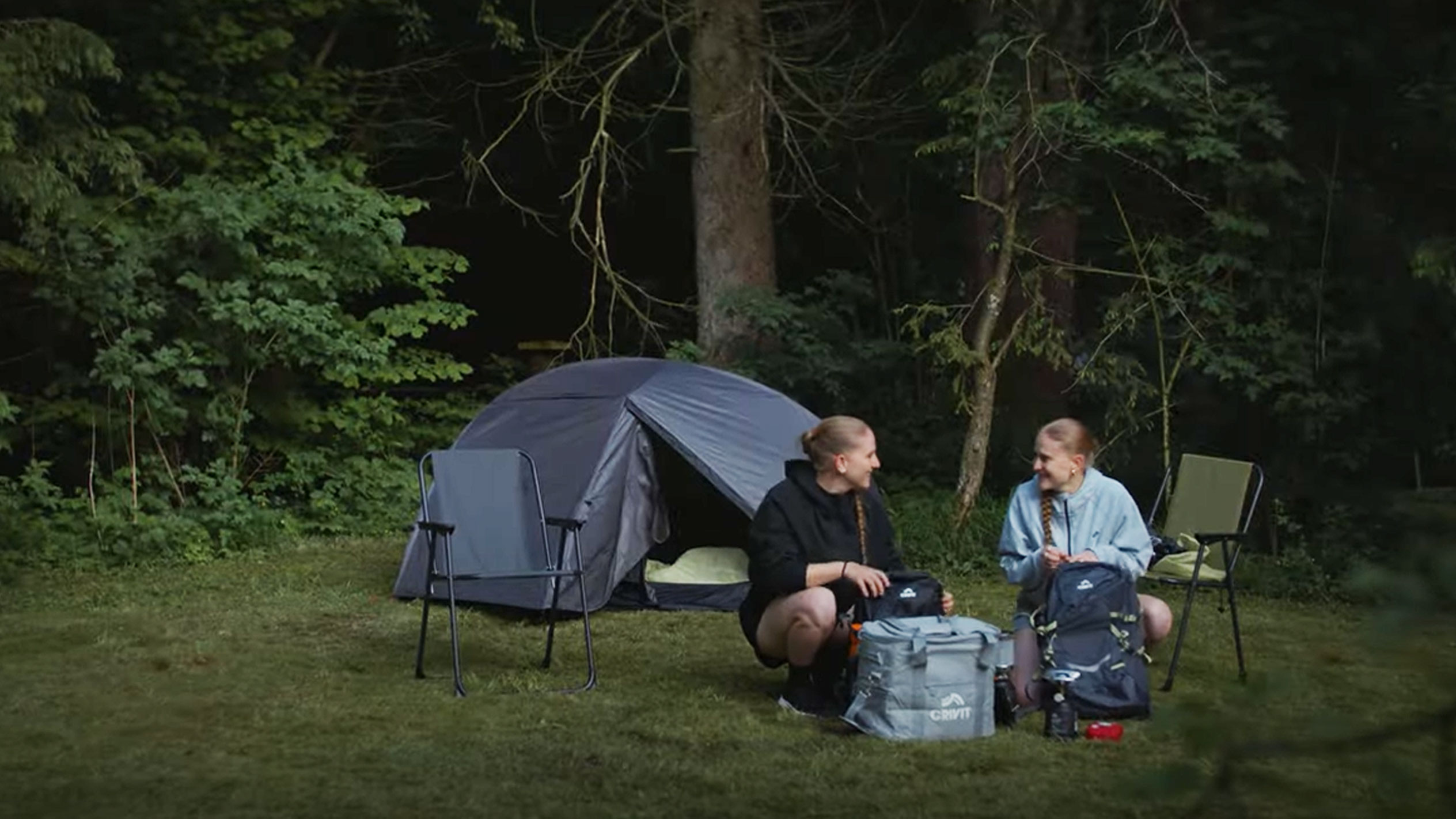 Twee vrouwen kamperen met een Crivit tent en opvouwbare stoelen.