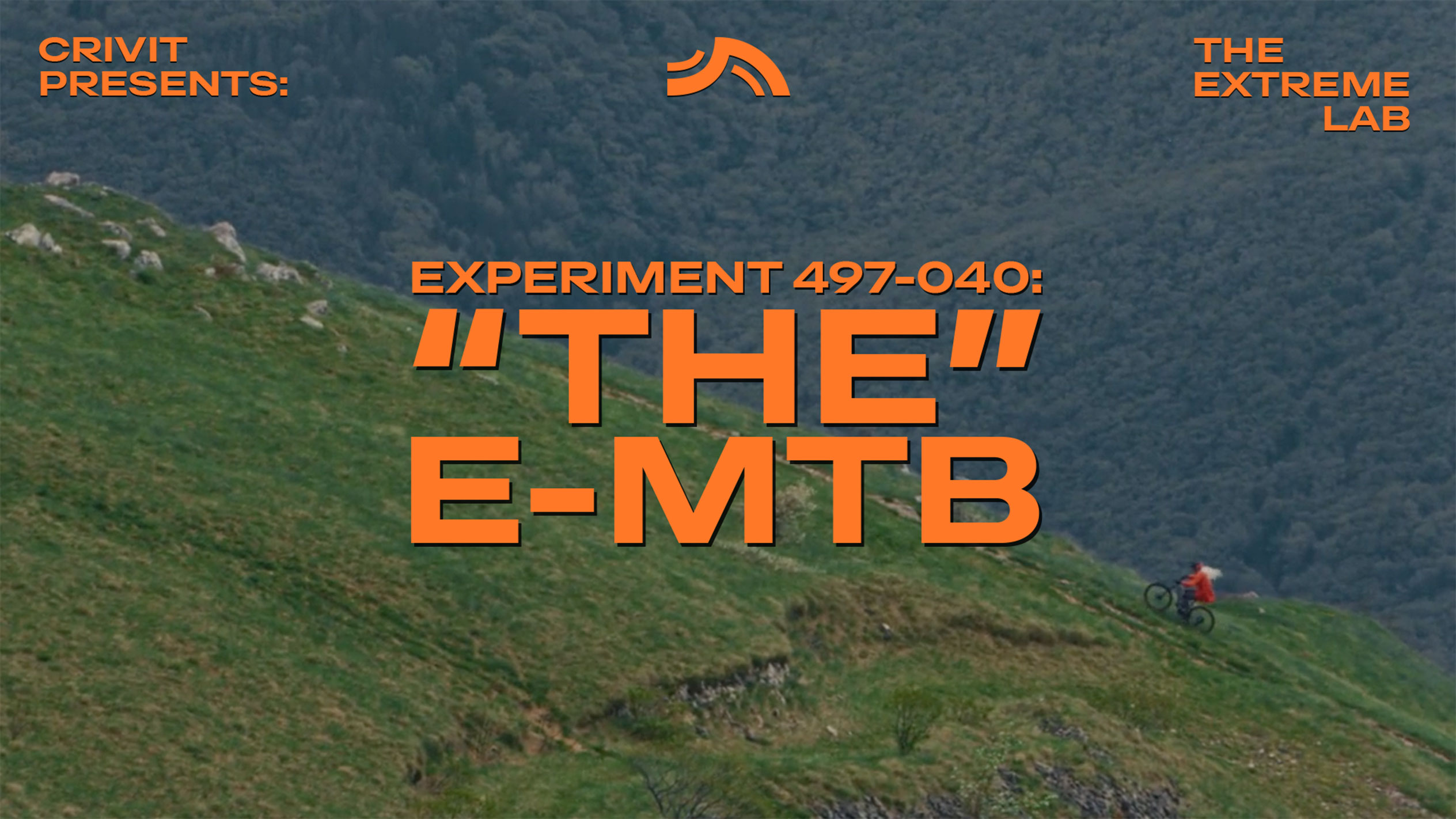Mountainbiker op een grashelling, met tekst 'THE E-MTB' en 'THE EXTREME LAB'.