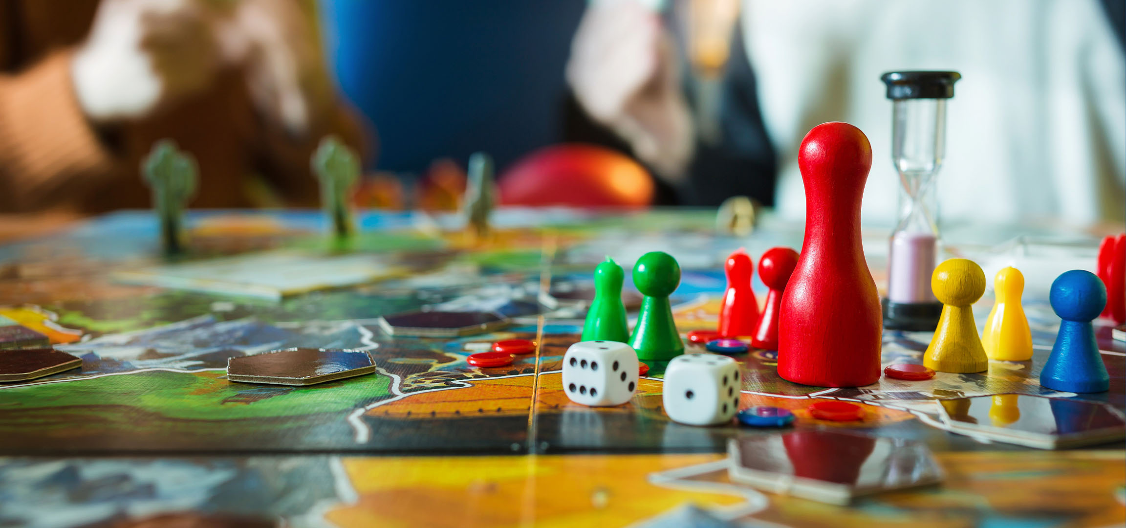 Kleurrijke bordspelstukken, waaronder rode, groene, gele en blauwe pionnen, met dobbelstenen.